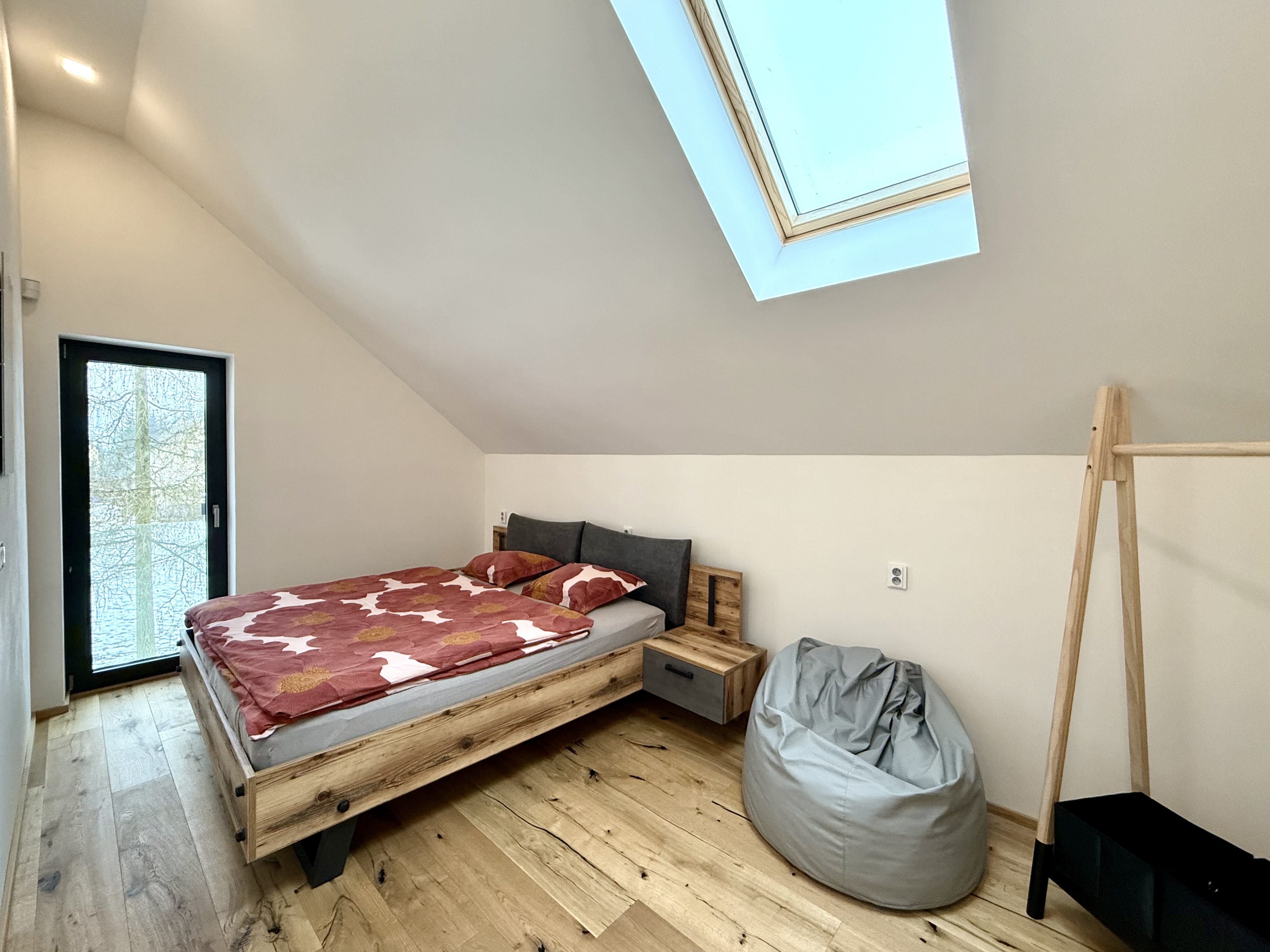 Ložnice s manželskou postelí a střešním oknem